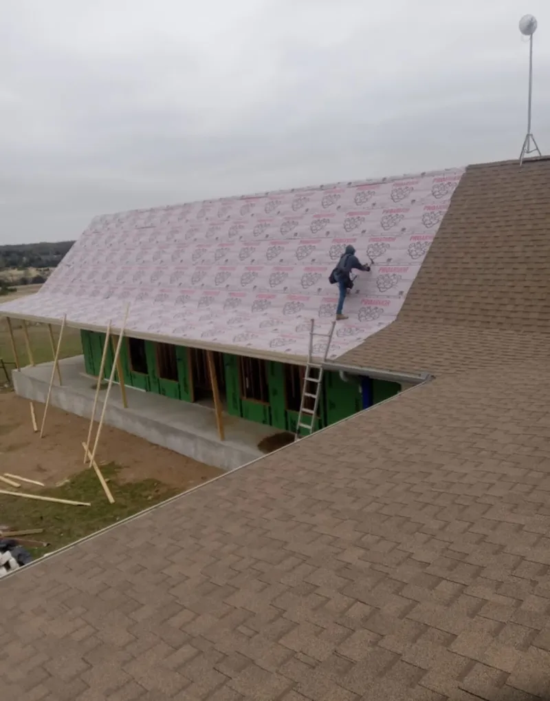 Worker preparing underlayment for a metal roof installation in Chattanooga